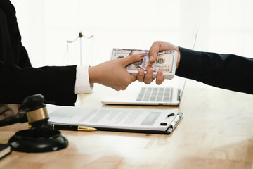 Two businessmen shake hands in an office, symbolizing agreement, partnership, and legal settlement....