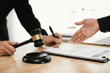 A professional lawyer discusses legal contracts with a client in an office, focusing on justice,...