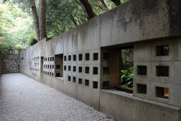Fototapeta premium Concrete wall with square openings in a garden pathway