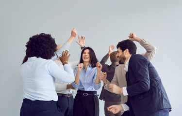 Multinational team of office colleagues celebrates success by dancing together. The group shares...