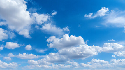 Obraz premium Clear blue sky with soft white clouds, natural background, peaceful and minimal.