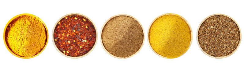 Set spice, turmeric powder, spicy chili red pepper flakes, cumin ground, curry, and anise seeds pile in bamboo bowl isolated on white background, top view, clipping path	