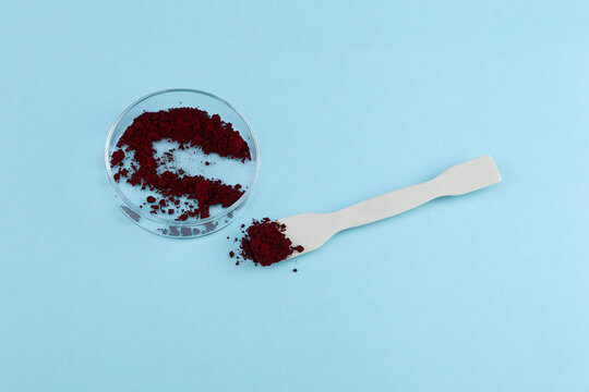 Azorubine or Carmoisine powder in Petri dish. Red synthetic food dye. Food colorant E122. Controversial additive, may have an adverse effect on activity and attention in children, ADHD-like behavior