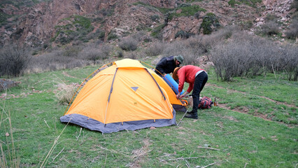 Camping life. Setting up a tent in a mountainous area. The wanderers travel the world together....