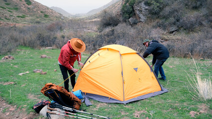 A couple of friends are engaged in mountain tourism. Two travelers spent the night in a beautiful...