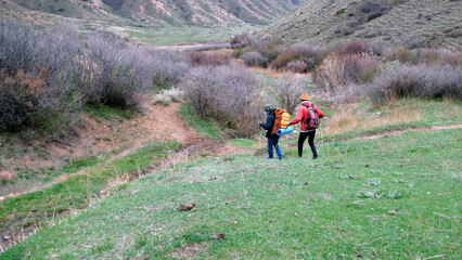 Two tourists strayed from their group. A couple of friends got lost on the green mountain slopes. Trekking, hiking