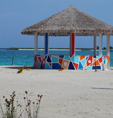 A colorful beach hut by the turquoise sea on the island Guraidhoo in the Maldives