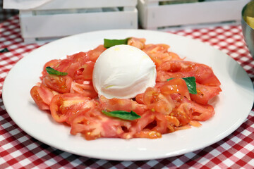 ensalada estilo italiana con tomate y mozzarella con hojas de albahaca