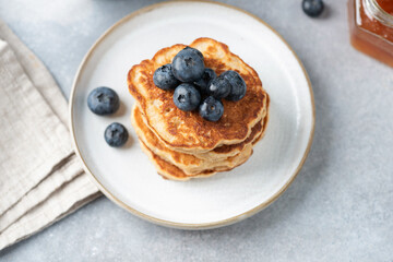 Stack of pancakes with blueberries on a white plate