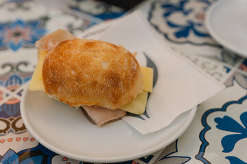 Ham and cheese sandwich on a tiled table in an Italian café