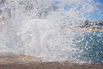 splashes of a beach wave crashing hard against a cement pier. Winter season.