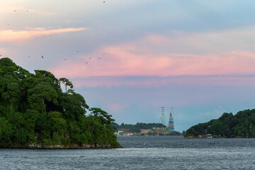 Offshore oil platform between tropical islands under sunset sky

