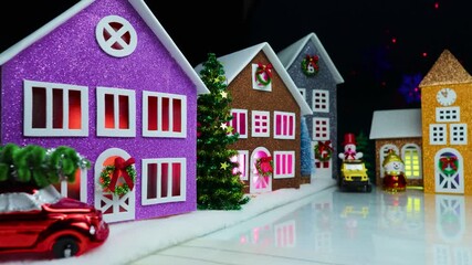 Beautiful Christmas town with snowmen near the chapel and colorful houses on a black background with animation