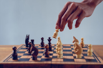 male hand moving chess piece on chess board game, business success, business competition planning...