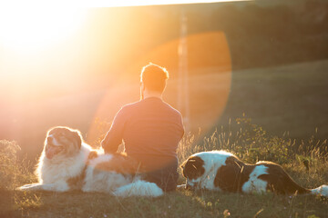 Happy dogs and man sitting outdoor