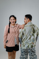 Cheerful Young Woman and Thoughtful Older Man Posing Together in Light Gray Background, Showcasing Modern Fashion and Joyful Expression