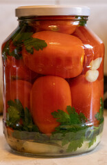 jars of pickled vegetables red pickled tomatoes, garlic, parsley, onion, winter preparation