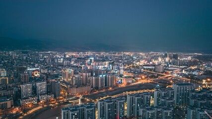 Aerial Panoramic View of Xichang City at Dusk with Modern Architecture and Mountain Backdrop, China