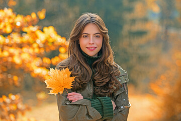 Autumn woman portrait in autumn fall. Woman with fall leaves. Romantic portrait in autumn foliage. Model on autumn nature. Woman with falling leaves.
