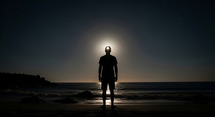 Mysterious silhouette of man standing on beach at night under the stars, concept of enlightenment