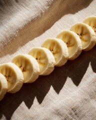 Sliced Bananas Arranged Neatly on a Natural Linen Surface with Soft Shadows and Warm Light