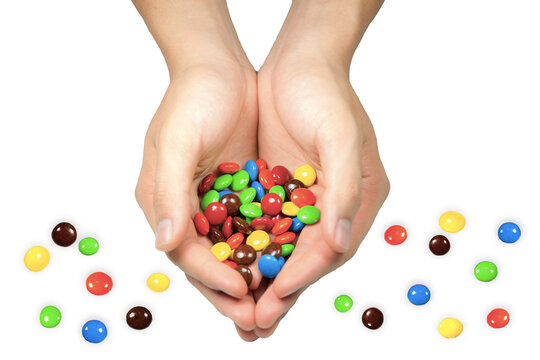 Hands holding colorful chocolate coated candy isolated on white background.