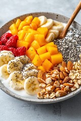 Healthy Breakfast Bowl with Fresh Mango Banana Raspberries Almonds and Chia Seeds for Health and Fitness