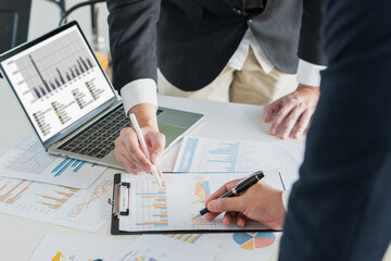businessman holds a pen while clarifying and discussing business information at the office table,...