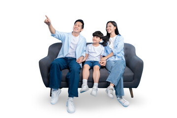 A loving family of three seated on a gray sofa, pointing upward on PNG 