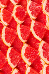 Grapefruit red juicy slices background. top view.