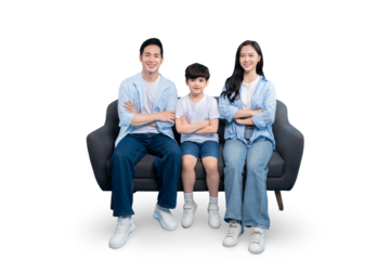Happy family sitting together on a gray sofa in a home setting. The image captures a moment of connection and love. The father, mother and child pose, their bodies forming a cohesive unit on PNG 