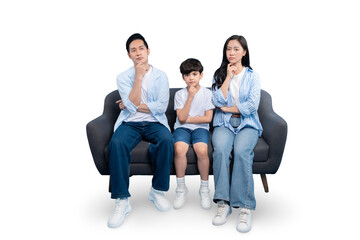 A thoughtful family sitting on a couch, each with a hand to their chin, deep in thought. The family...