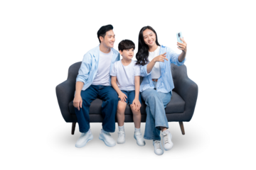 A happy family taking selfie.  Parents and their son sit on a couch while the mother holds a phone taking a picture on PNG