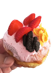 Hand Holding a Freshly Baked Strawberry Topped Donut