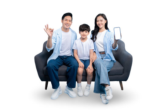 A happy family of three seated together while presenting a mobile phone with a blank screen. The parents and child are all smiling, conveying happiness and contentment on PNG 
