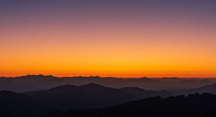 Obraz premium Vibrant sunset over mountain range with orange and purple sky