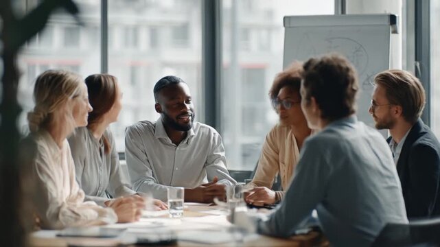 Diverse group of colleagues engaged in a productive meeting around a table in a modern office.