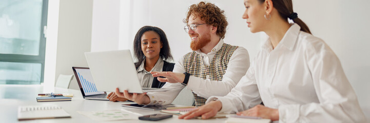 A diverse and dynamic team is actively engaging in a collaborative work session utilizing their...