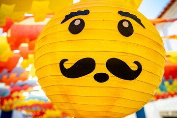 Yellow paper ball with a representation of a human face with a mustache and a surprised reaction at the paper flower festival organized by the town of Redondo-&Eacute;vora-Portugal
