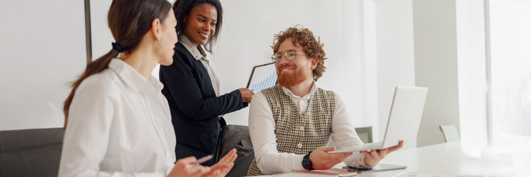 A diverse team has a productive meeting, discussing innovative ideas using various tech tools for collaboration - Powered by Adobe