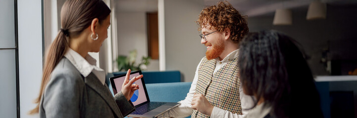 A collaborative team engaging in insightful discussions while using a laptop in a modern, innovative workspace