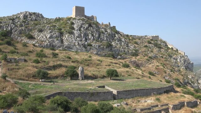 The remains of temples and structures at the top of Acrocorinth, with a view over the plains of Corinth.