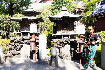 Travelers thai women people travel visit take photo with holy small antique shrine in garden park...