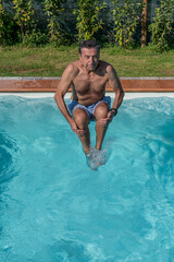 Man cannonball dives into a swimming pool