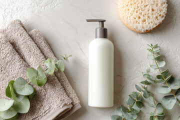 Minimalist body lotion pump bottle is placed on textured surface, surrounded by soft towels, natural sponge, and fresh eucalyptus leaves, creating serene and inviting atmosphere
