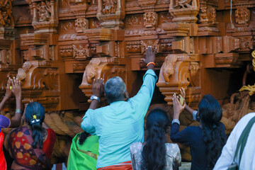 Devotees pulling a grandly decorated temple chariot during the Aadi festival at Kallalagar Temple,...