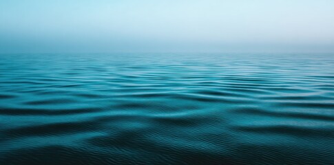 Fototapeta premium Calm, rippled teal water surface, soft light, misty atmosphere