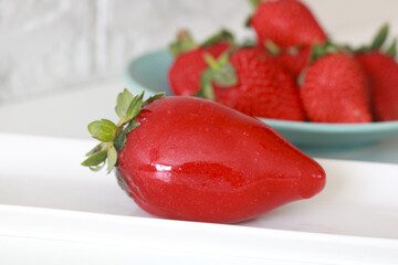 Close-up of a bright strawberry covered in candy, a traditional 