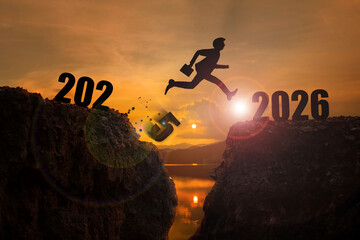 2026,Welcome Merry Christmas and Happy New Year 2026 Silhouette Man jumps from the cliffs of 2025...
