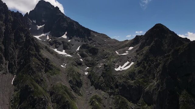 Aerial view of Avusor Highland in Kackarlar, Rize, Turkey, featuring majestic rocky mountains with snow patches under a clear blue sky